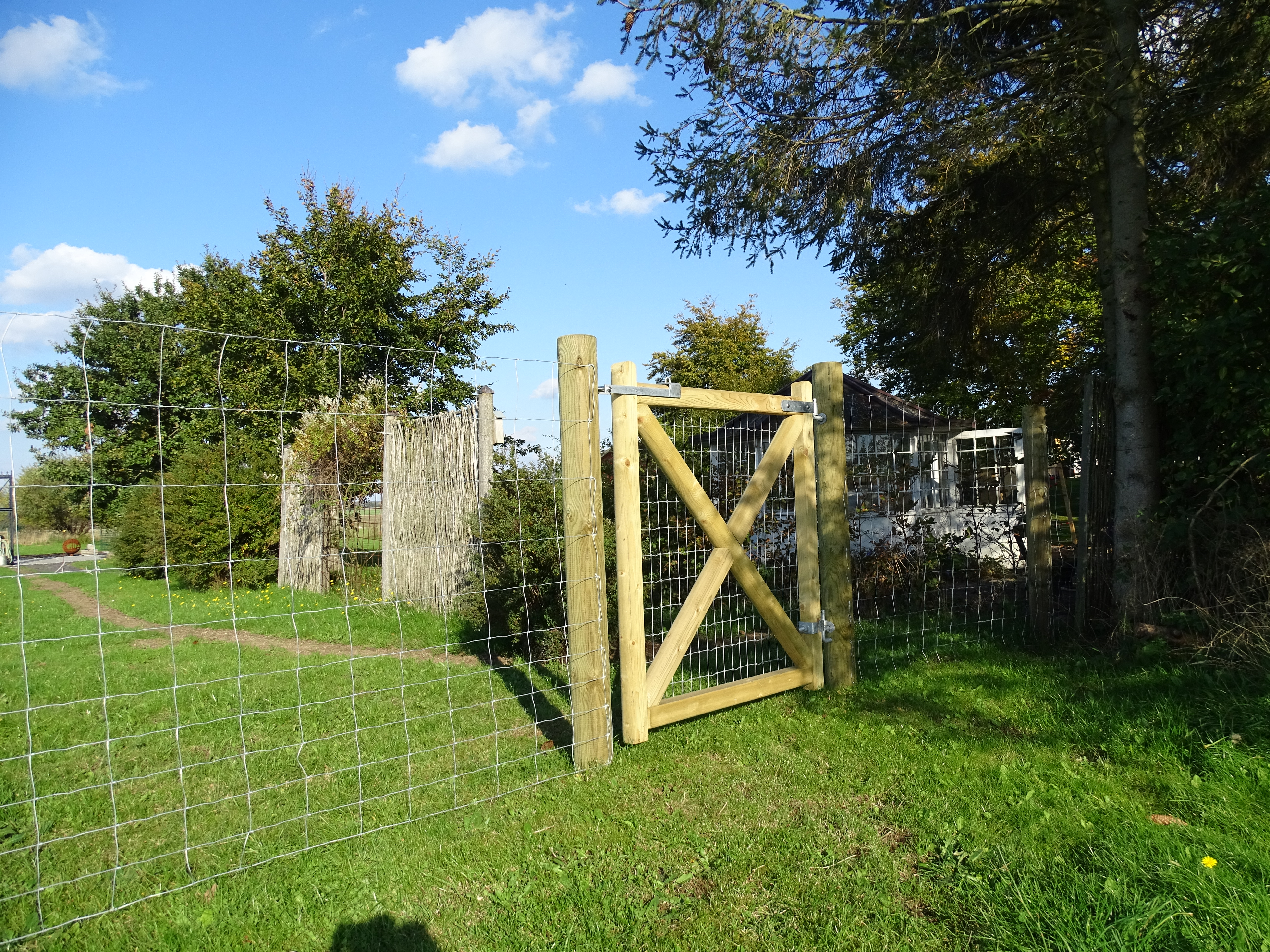 En lukket «Country Estate»-grind er installert i en hage