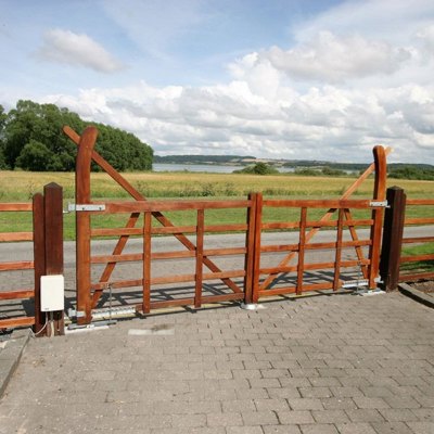 En Country Ranger-grind er montert ved siden av en vei. I bakgrunnen er det et jorde og en innsjø.