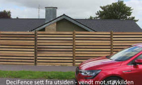 DeciFence støygjerde sett utenfra med bil foran boligområde.
