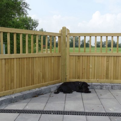 En hund som tar seg en lur foran et «Country Garden»-gjerde