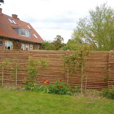 Hagegjerder laget av rafter med bark som brukes som barriere mellom to hager