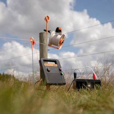 "En multipower-strømgiver er satt opp på et gjerde på en mark."