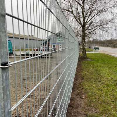 I et industriområde er det satt opp et grått panelgjerde for å beskytte en bedrift