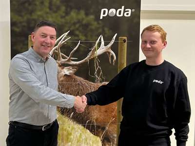 Poda-direktør Peter håndhilser på Sofus fra Poda Hegn Ringe, foran et banner med hjort og elektrisk gjerde.
