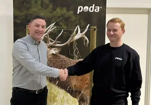 Poda-direktør Peter håndhilser på Sofus fra Poda Hegn Ringe, foran et banner med hjort og elektrisk gjerde.